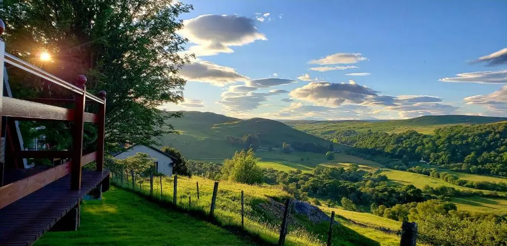 a building on a hill with a view of a valley at Highland Glen Lodges in Rogart