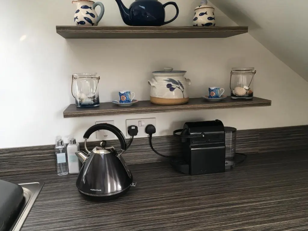 a kitchen counter with a tea kettle on a stove at Riverbank Apartments in Nairn