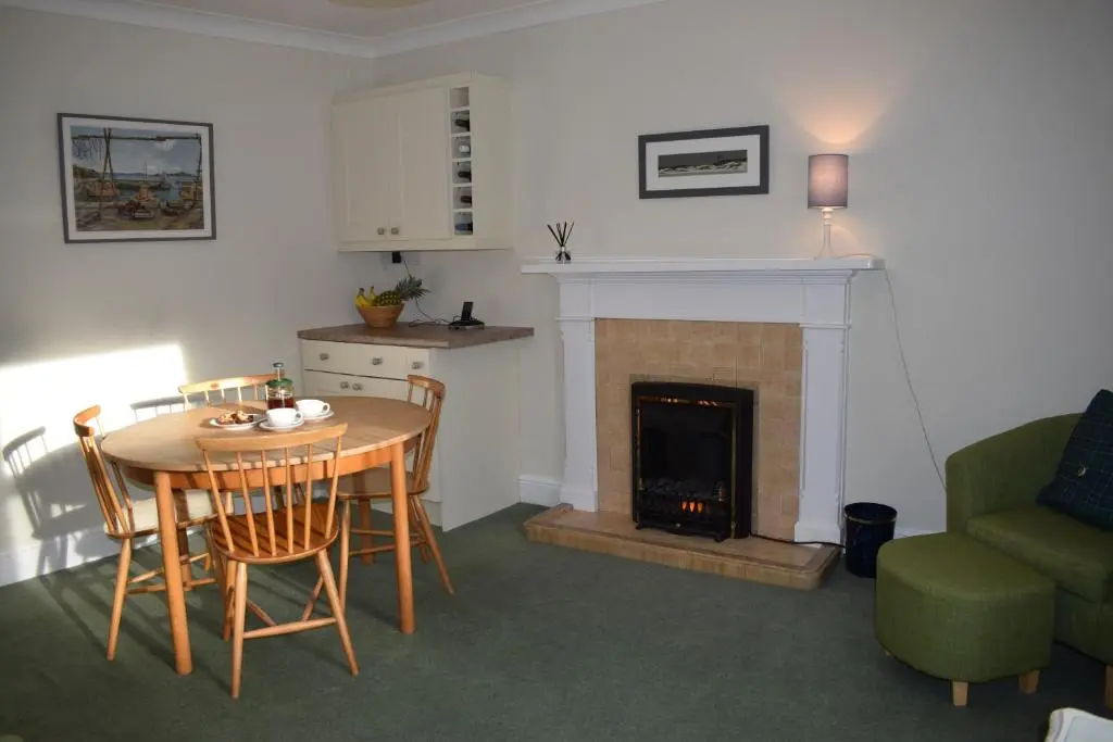 a living room with a table and a fireplace at 3 St Gilbert Street in Dornoch