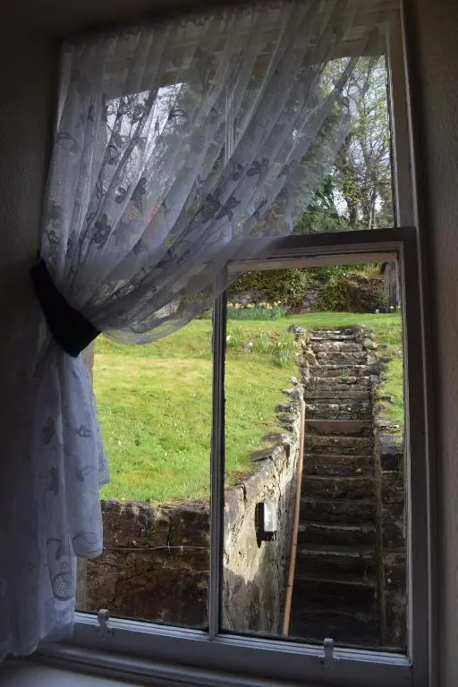 a window with a view of a stone staircase at 3 St Gilbert Street in Dornoch