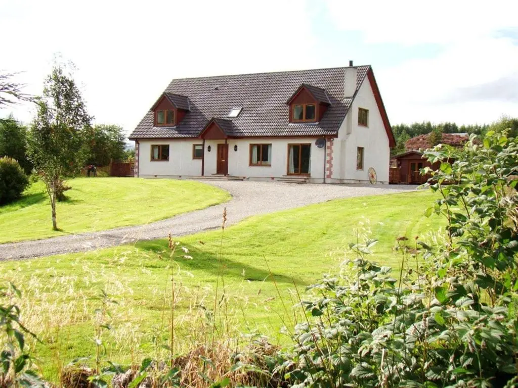 a large white house with a grassy yard at Binnilidh Mhor B&B in Glenmoriston