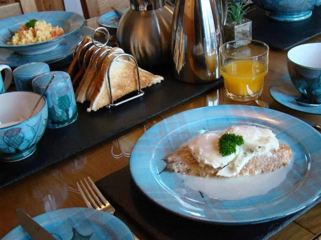 a table with a plate of food on a table at Binnilidh Mhor B&B in Glenmoriston