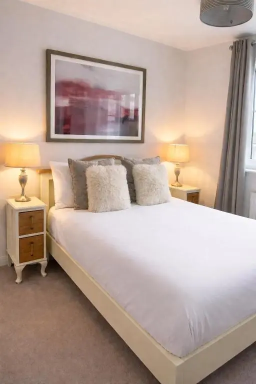 a bedroom with a large white bed with two lamps at Lily Bank House in Inverness