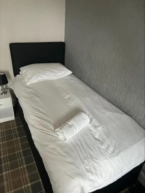 a bed with a roll of paper towels on it at Whisky Capital Inn in Dufftown