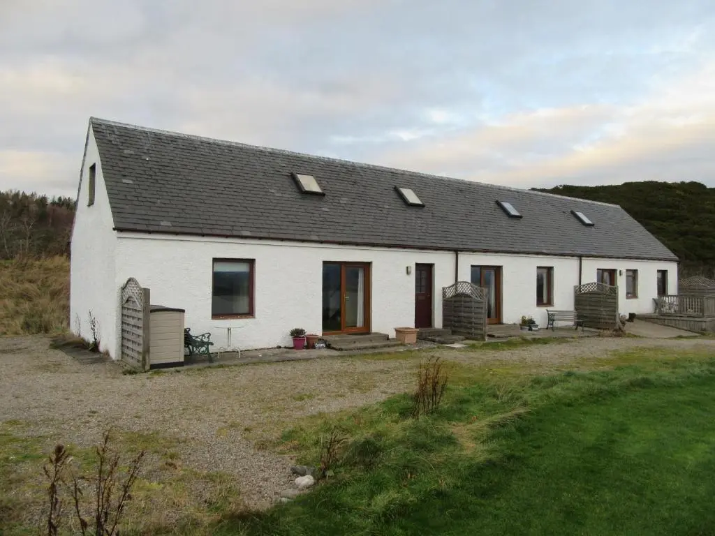 a white house with a black roof at Osprey, Longhouse Cottages in Rosemarkie