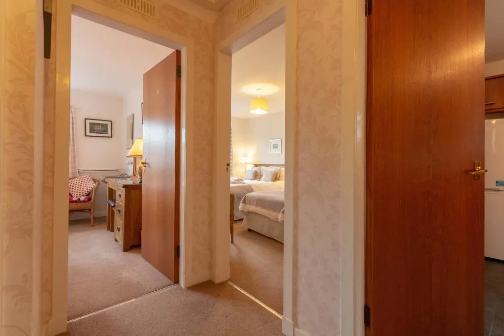 a hallway leading to a bedroom with a bed and a bathroom at Beachview-Holiday Flat 2- Sleeps8 in Lossiemouth