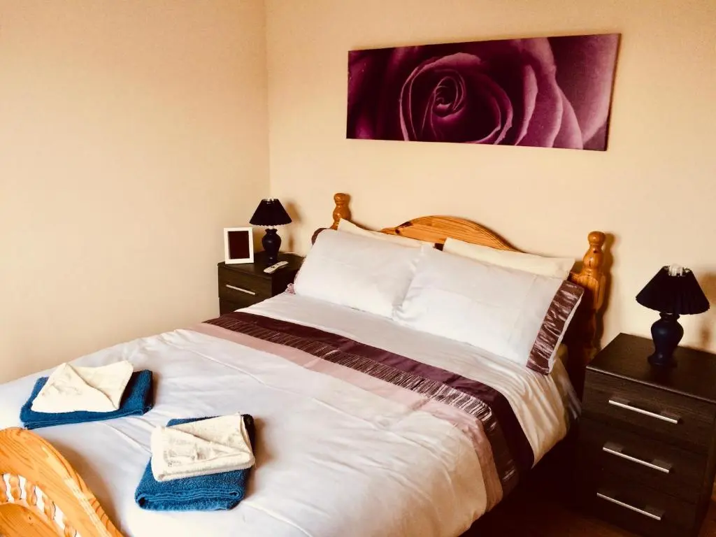 a bedroom with a large bed with a flower on the wall at Invercaul House in Inverness