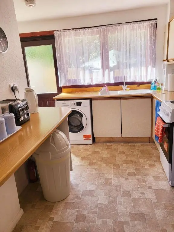 a kitchen with a sink and a washing machine at Invercaul House in Inverness
