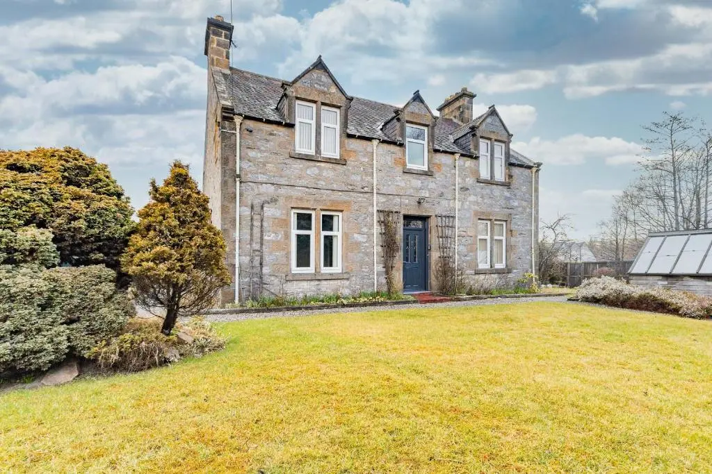 an old stone house with a large yard at Convalmore House in Dufftown