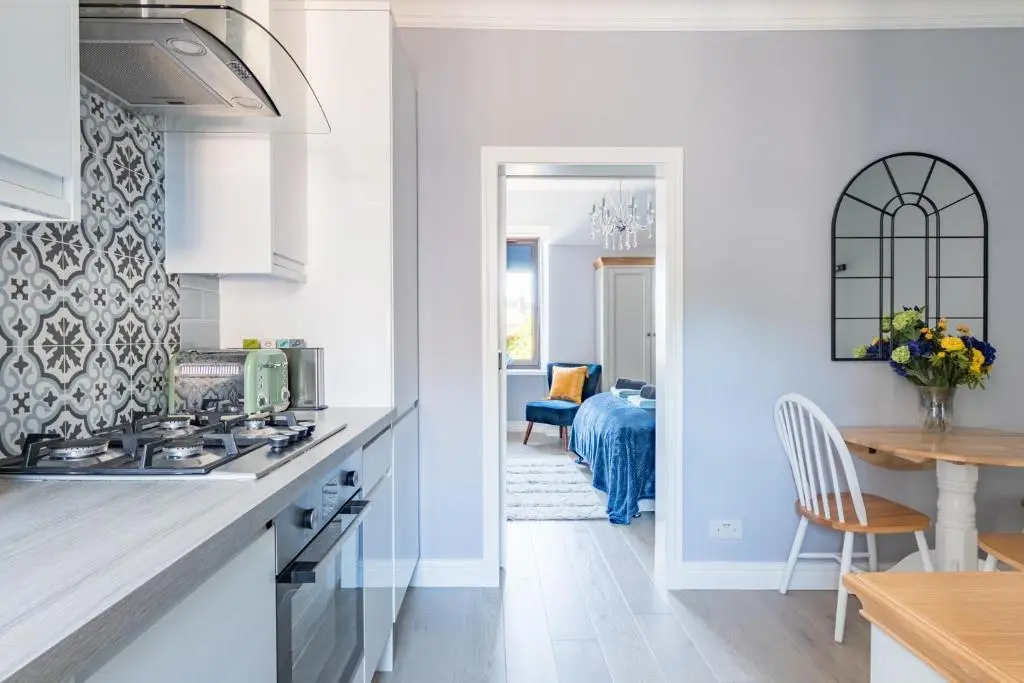 a kitchen with white cabinets and a dining room at BlueNess in Inverness