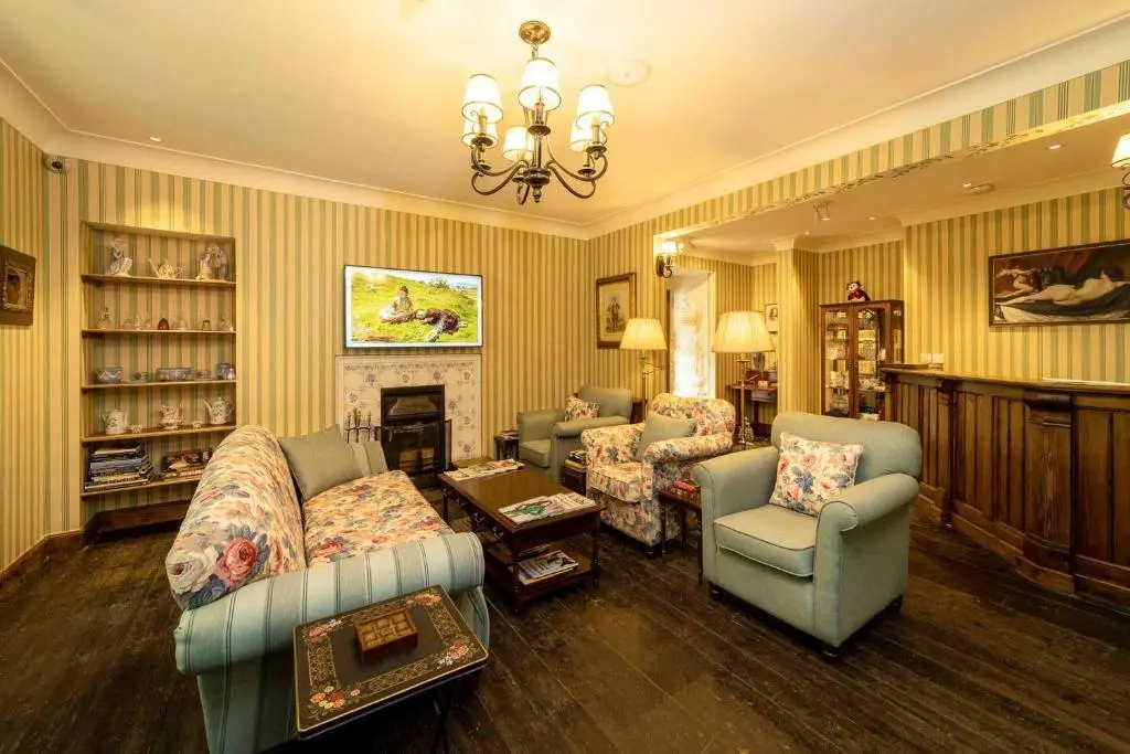 a living room with couches and chairs and a fireplace at Rokeby Manor in Invergarry