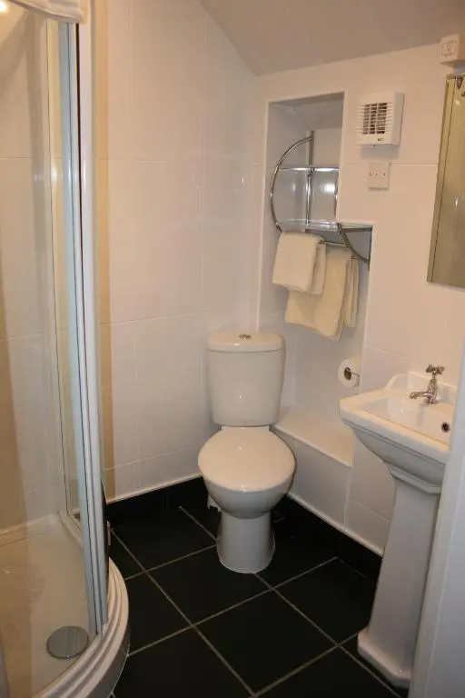 a white bathroom with a toilet and a sink at Ardmeanach in Inverness