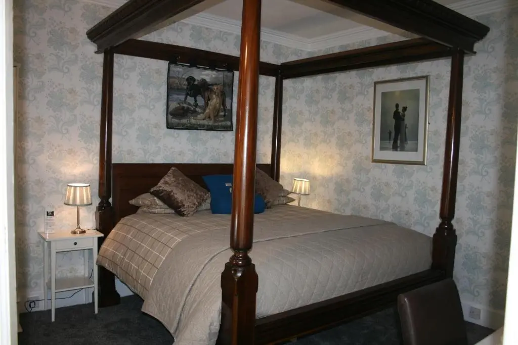 a bedroom with a four poster bed in a room at Ardmeanach in Inverness