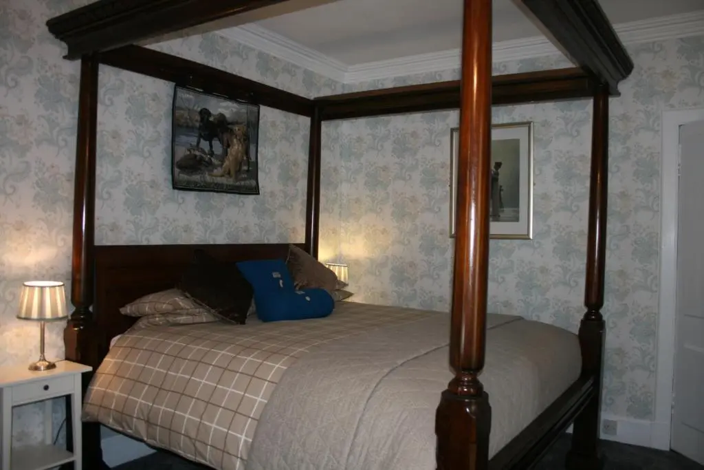 a bedroom with a bed with a canopy at Ardmeanach in Inverness