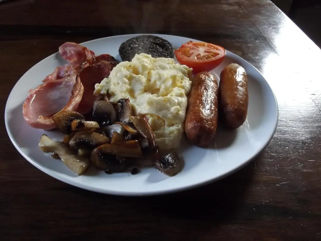 a plate of breakfast food with eggs bacon and mushrooms at Ardmeanach in Inverness