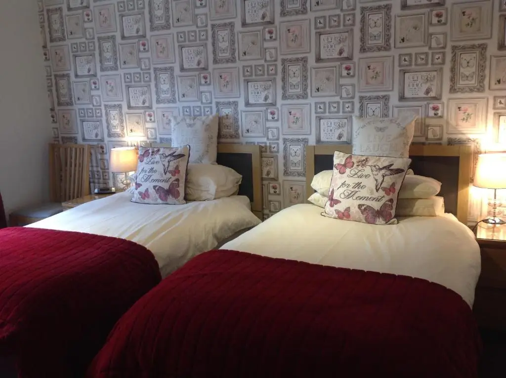 two beds sitting next to each other in a room at Dunroamin Bed and Breakfast in Aviemore