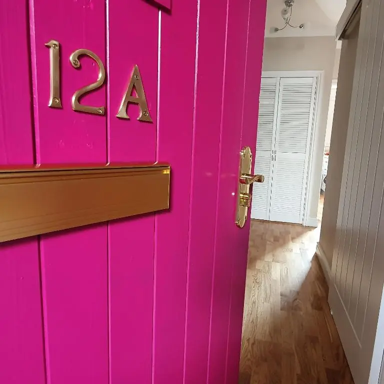 a pink door with the letters ra on it at Smart & Cozy Holiday Apartment in the city centre in Inverness