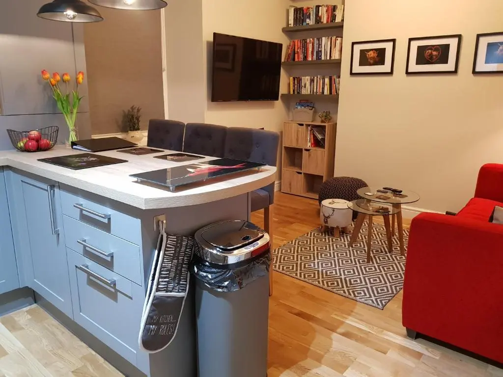 a kitchen with a blue island in a living room at Smart & Cozy Holiday Apartment in the city centre in Inverness