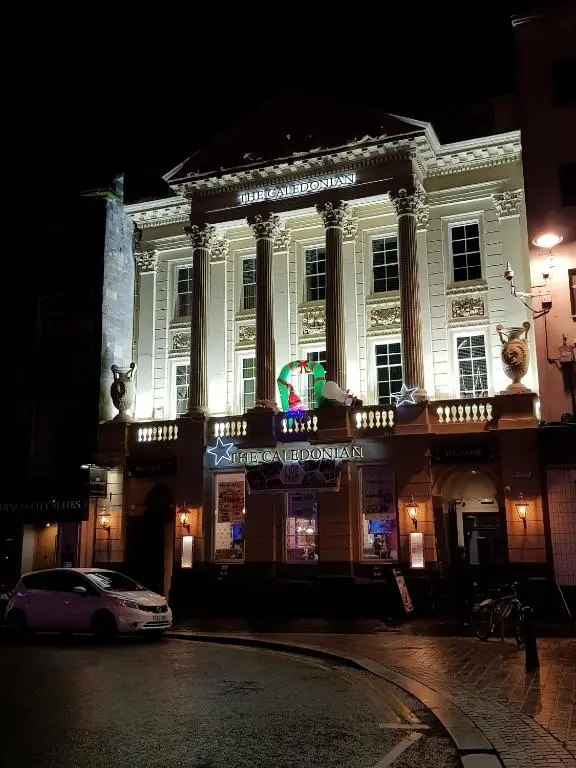 a building with a car parked in front of it at Smart & Cozy Holiday Apartment in the city centre in Inverness