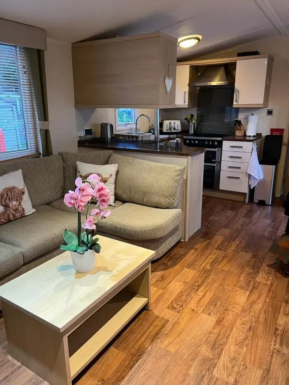 a living room with a couch and a table with flowers at Braemar in Dornoch