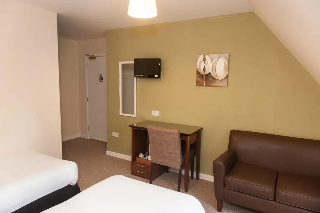 a hotel room with a bed and a desk and a couch at Ardross Glencairn in Inverness