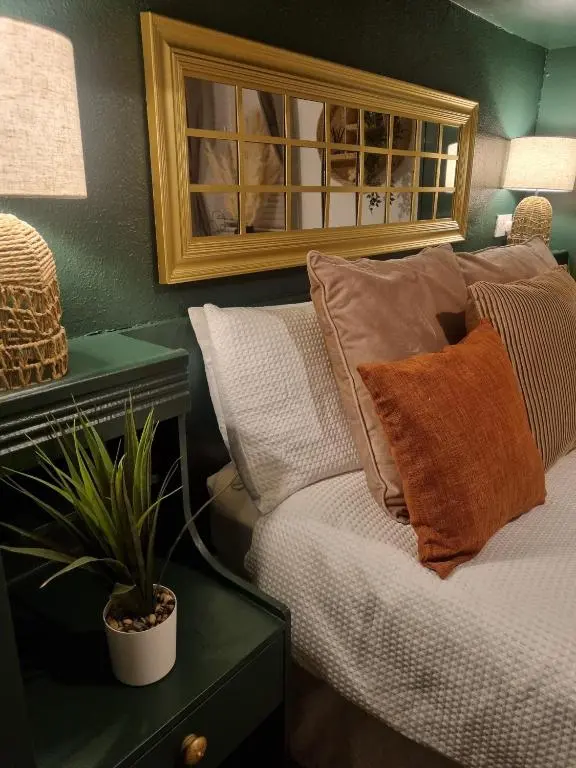 a bedroom with a bed with pillows and a plant at Inverness City Centre Flat in Inverness