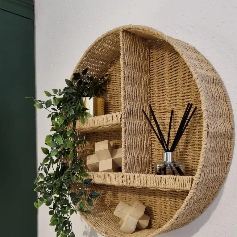 a wicker wicker shelf with a plant on a wall at Inverness City Centre Flat in Inverness