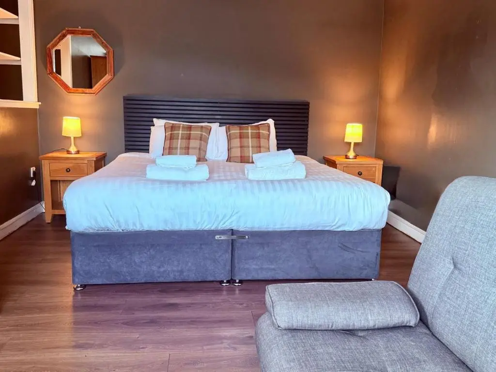 a bedroom with a large bed and a couch at Argyll Hotel in Ullapool