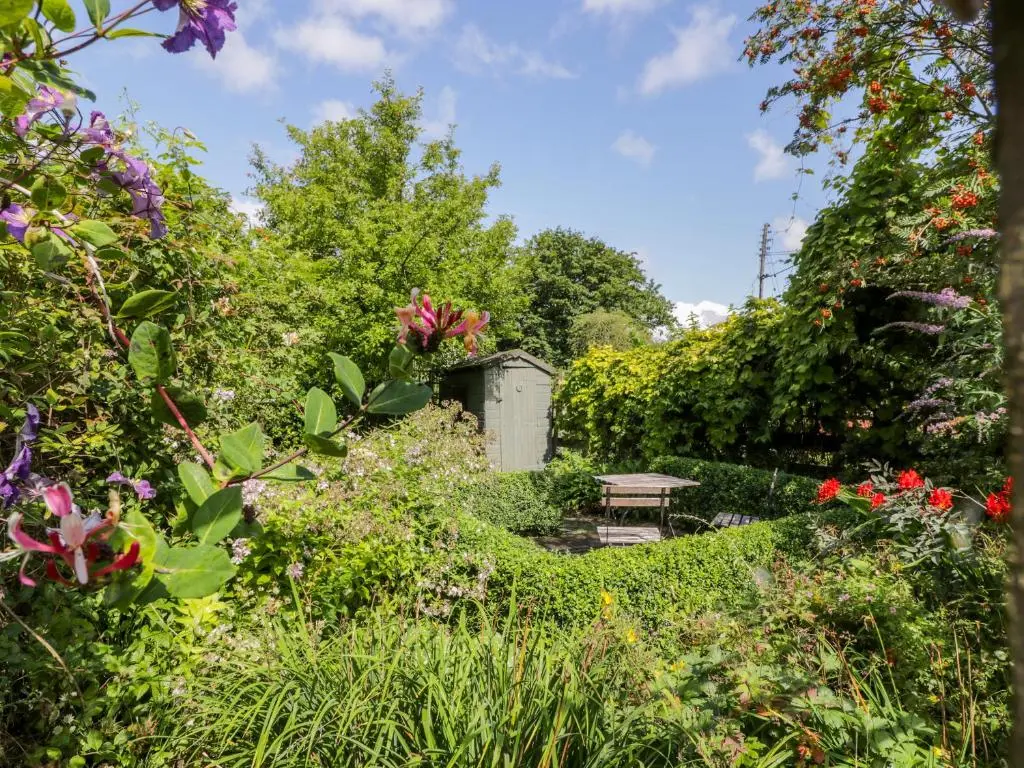 a garden with a bench and some flowers at Church View in Kingussie