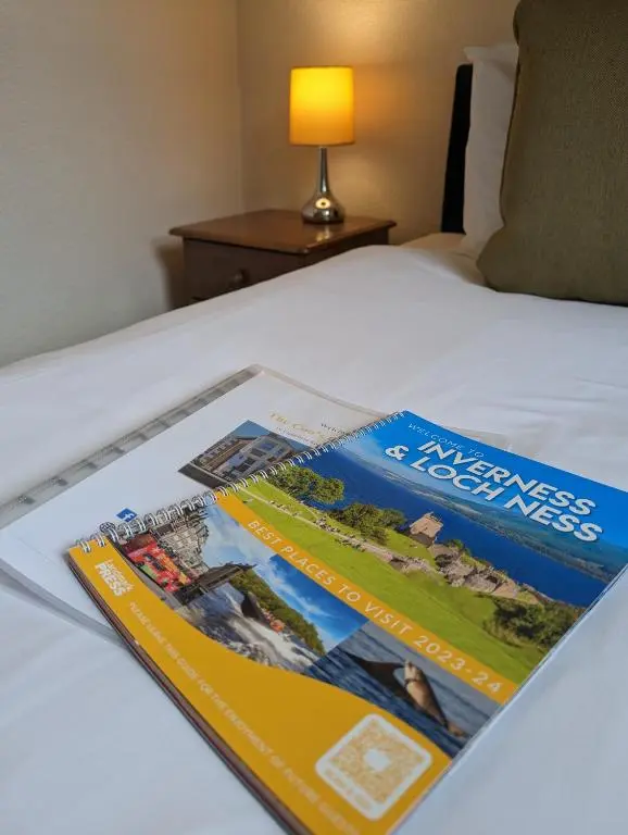 a magazine sitting on top of a bed at The Coo's Guest House in Inverness
