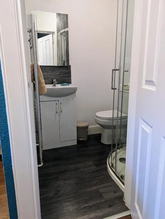a bathroom with a toilet and a sink and a mirror at The Coo's Guest House in Inverness
