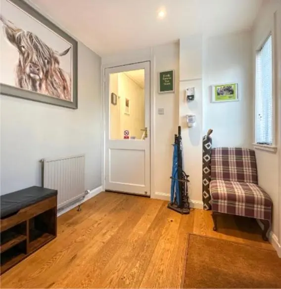 a living room with a chair and a door at Clune House B&B in Newtonmore