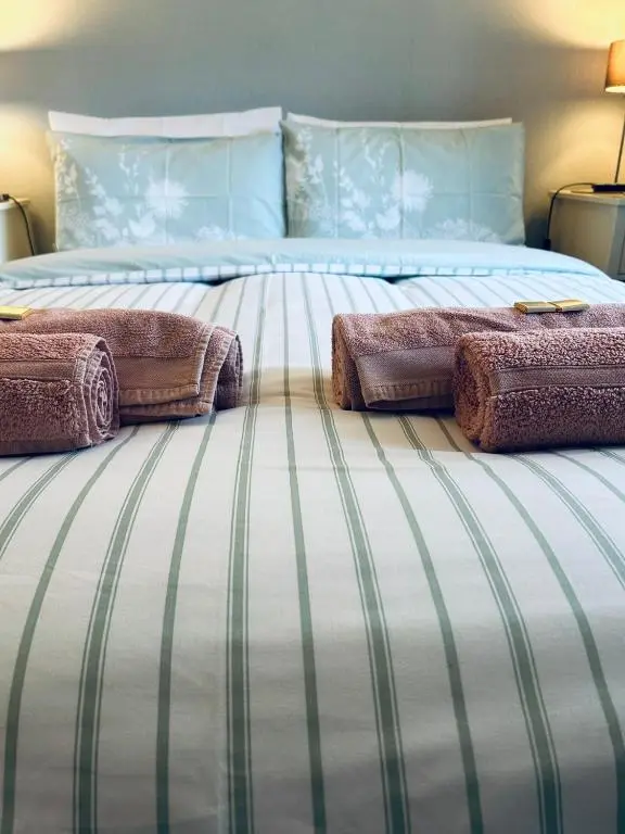 a large bed with two pillows on top of it at The Maples 26 Wellingtonia Court in Inverness