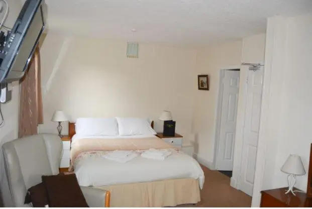a bedroom with a bed and a desk and a chair at Queens hotel in Wick