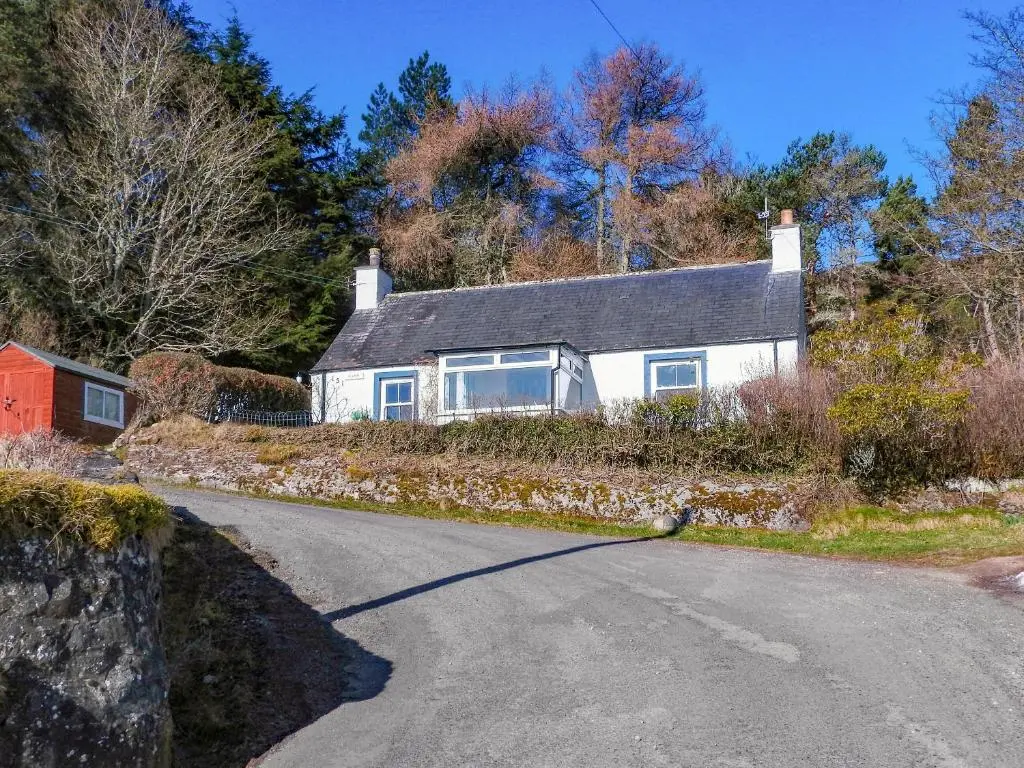 a white house on the side of a road at Farr in Helmsdale
