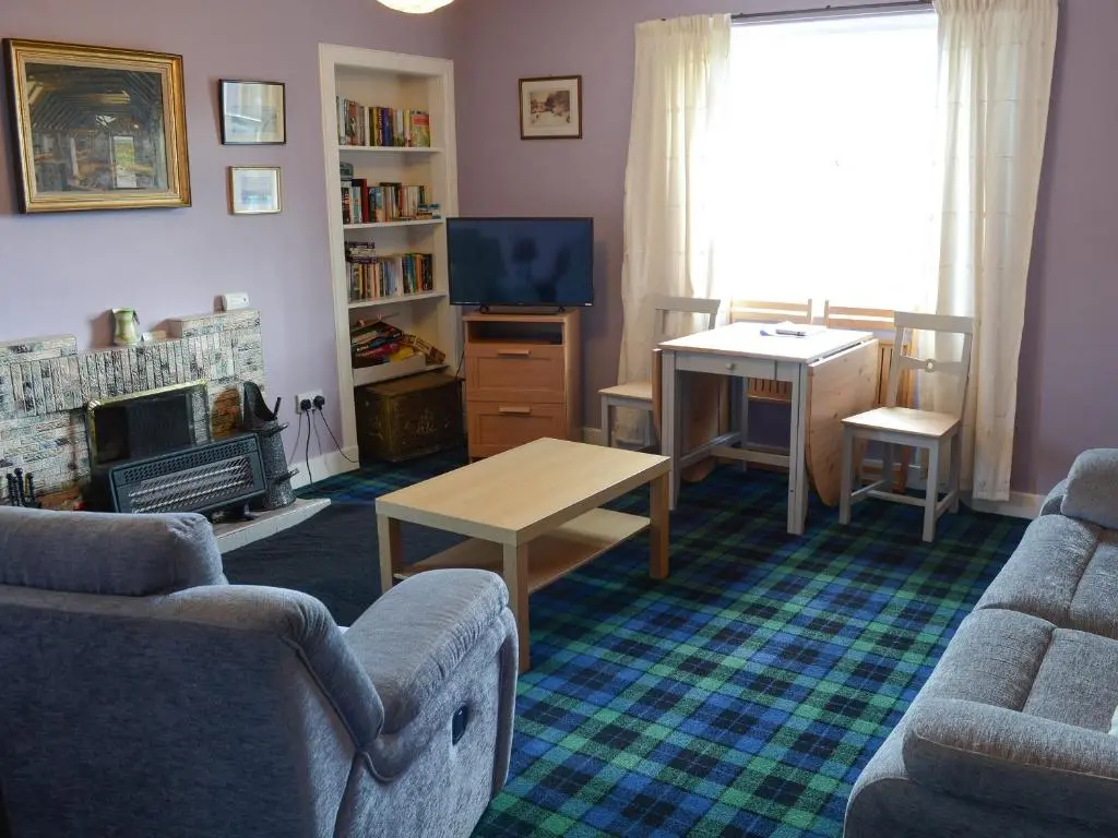 a living room with a couch and a table at Farr in Helmsdale