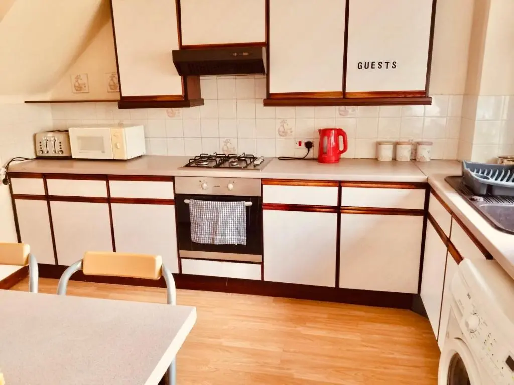 a kitchen with white cabinets and a stove top oven at Inverken House in Inverness
