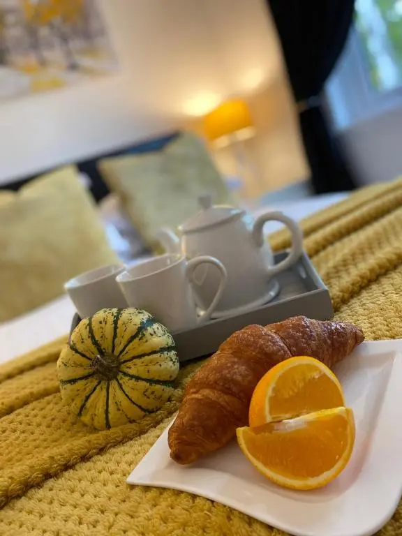 a plate of food with an orange slice and a tea pot at Druid House Lodge in Inverness