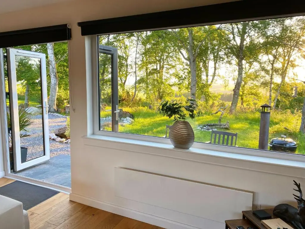 a window in a living room with a view of a yard at Druid House Lodge in Inverness