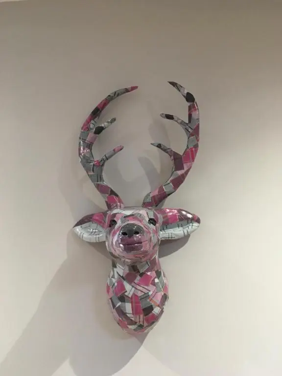 a statue of a reindeer hanging on a wall at Corran Cottage in Inverness