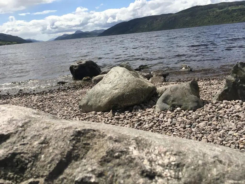 a group of rocks on the shore of a body of water at Corran Cottage in Inverness
