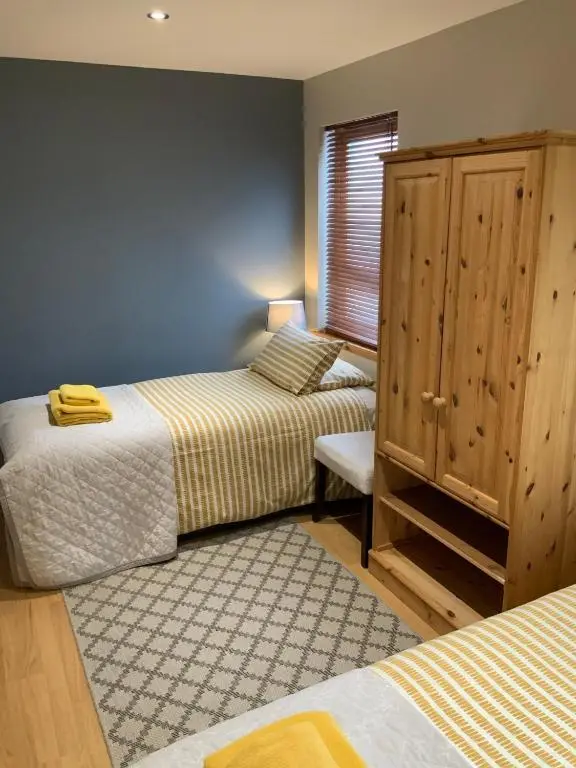 a bedroom with two beds and a cabinet in it at Corran Cottage in Inverness