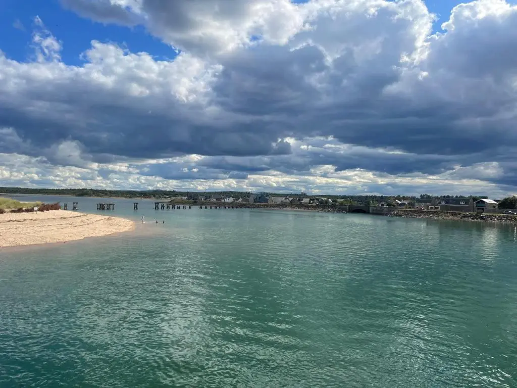 a body of water with a beach and a cloudy sky at The Jewel of the Moray Firth in Lossiemouth