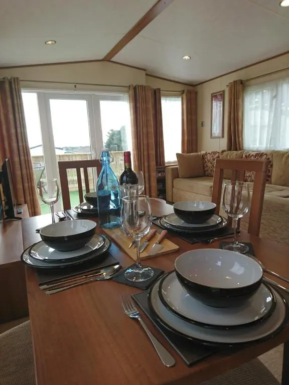 a dining room table with plates and wine glasses on it at No42 Wild Goose in Dornoch
