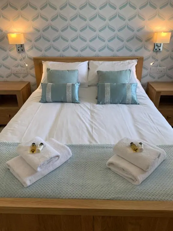 a bed with towels and two teddy bears on it at Greenfield Cottage in Thrumster