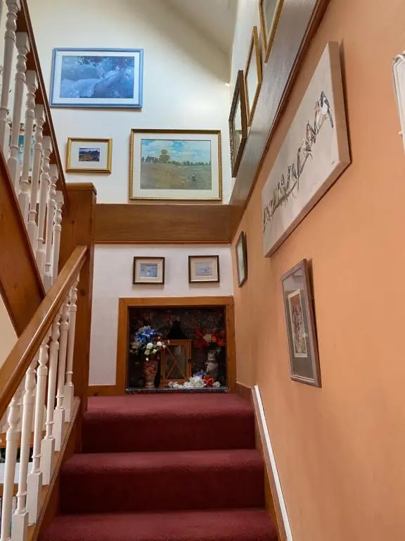 a staircase in a home with paintings on the walls at Bosta B&B in Inverness