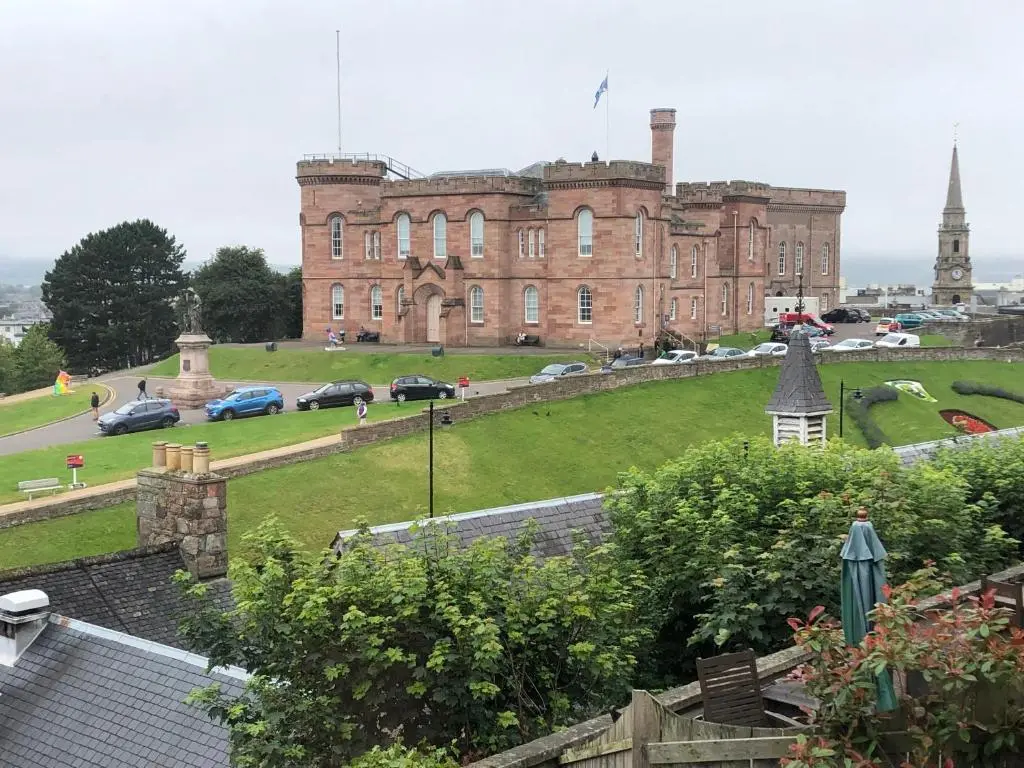 a large brick building with cars parked in front of it at Redcliffe Hotel in Inverness
