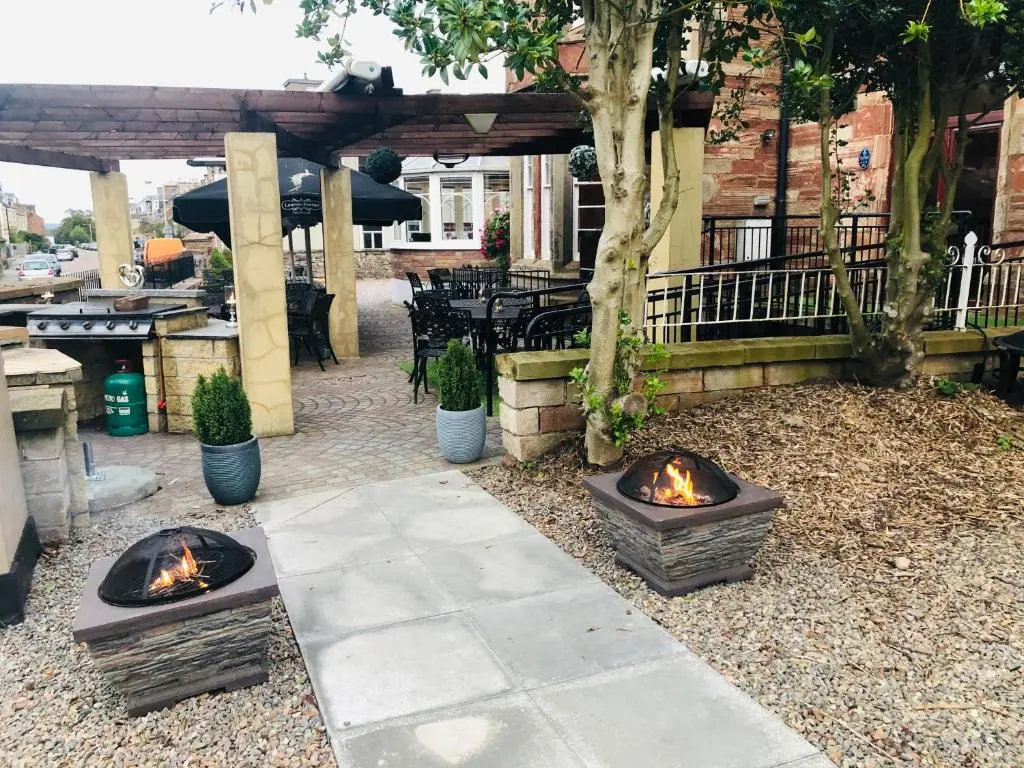 a patio with three fire pits on the ground at Redcliffe Hotel in Inverness