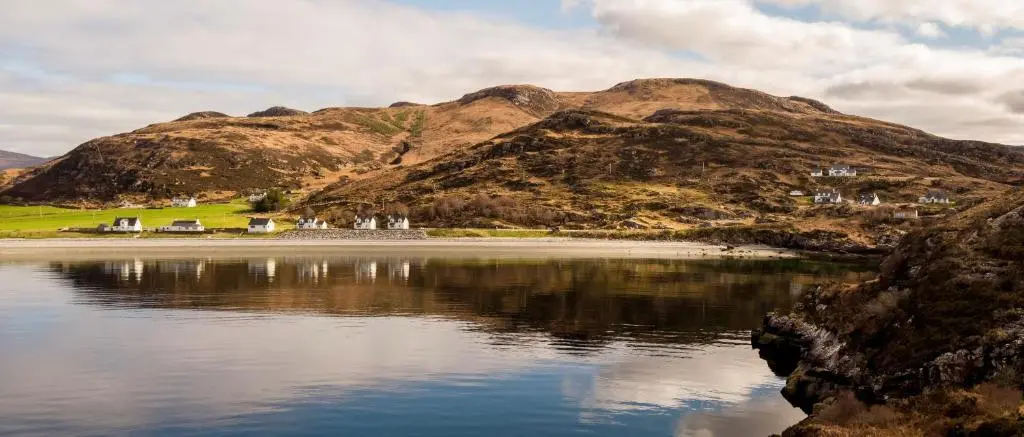 a body of water with a mountain in the background at Tigh na Mara in Ullapool
