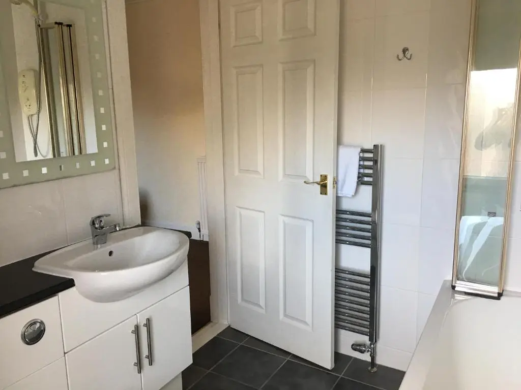 a bathroom with a sink and a white door at No 29 Bed and Breakfast in Inverness